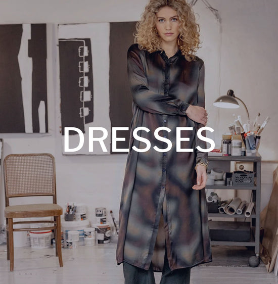 Model wearing Project AJ117 dress in an art studio with the word dresses written across it