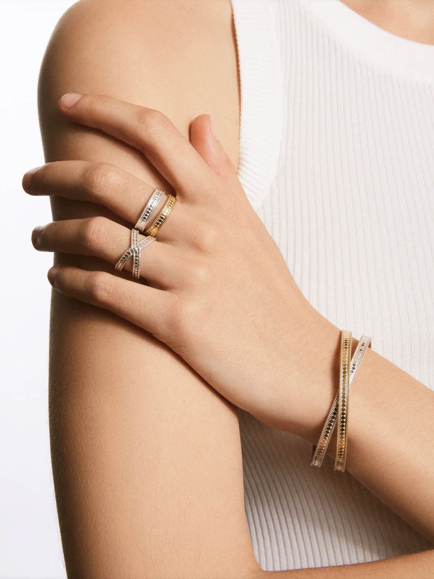 Anna Beck Classic Cross Cuff Gold  & Silver Bracelet close up on models arm with matching rings
