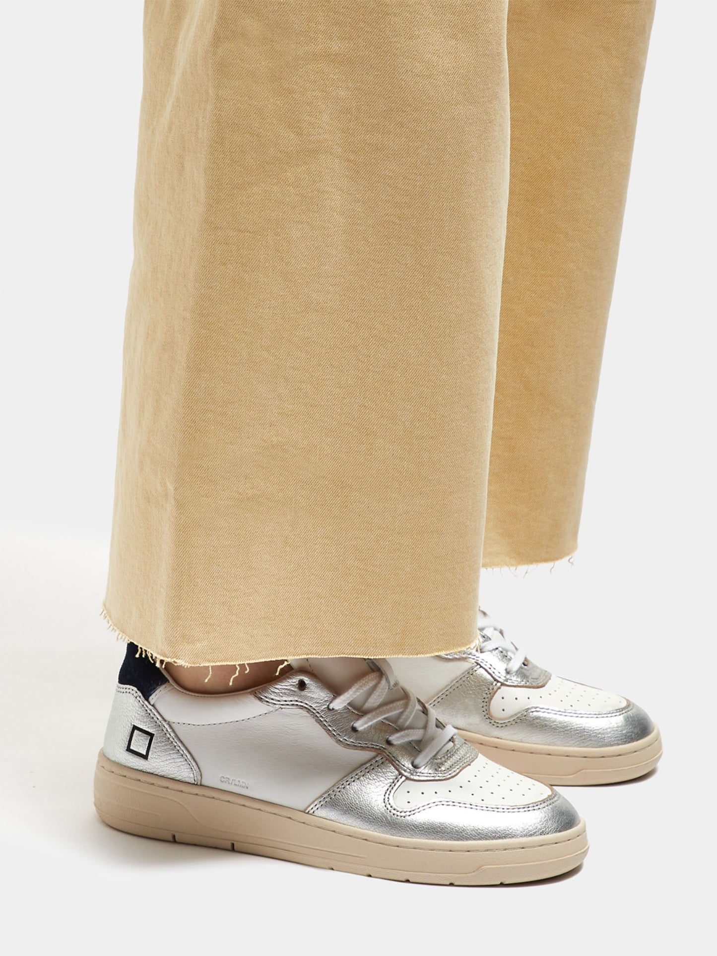 D.A.T.E Court Laminated White Silver Trainers on model with yellow trousers