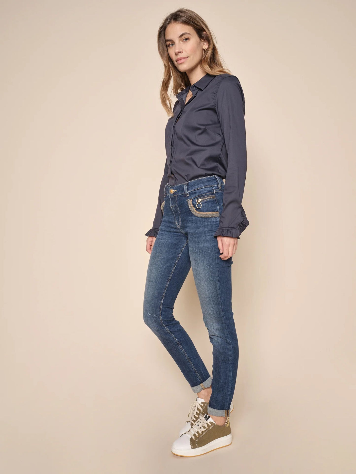 Model wearing a blue silk shirt and Mos Mosh Naomi Achilles Jeans Dark Blue with trainers