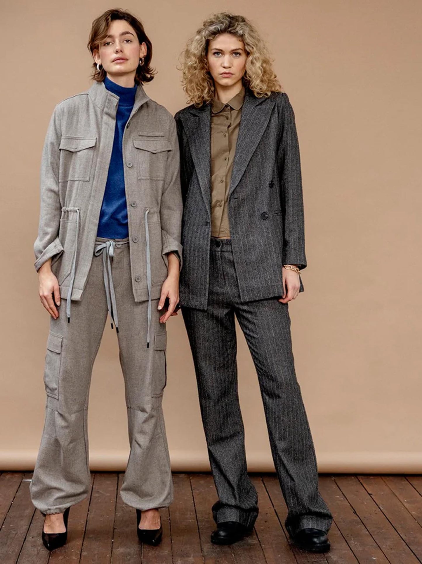 Two models wearing suits from Project AJ117 in grey tones from the Autumn/Winter 23 collection